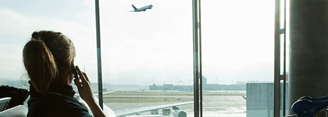 Frau telefoniert am Flughafen