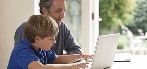 Vater bringt seinem Sohn den Umgang mit dem Internet bei