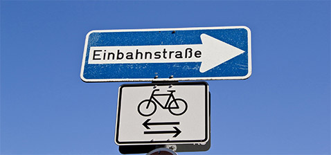 Straßenschild Einbahnstraße und Fahrräder