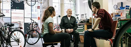 Unternehmensnachfolge leicht gemacht Unternehmer unterhält sich mit jungen Mitarbeitern