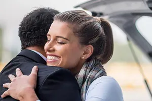 Frau begrüßt Mann am Flughafen Frau begrüßt Mann am Flughafen