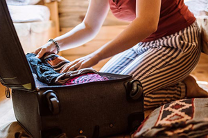 Frau beim Packen ihres Koffers Frau beim Packen ihres Koffers